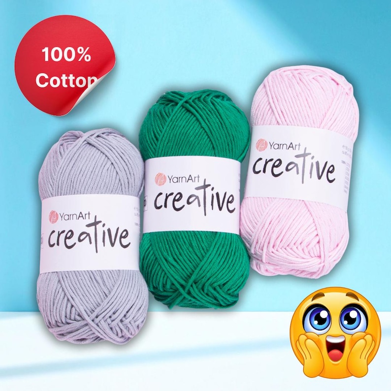 May include: Three balls of YarnArt Creative yarn in grey, green, and pink. Each ball has a white label with the word "creative" printed on it. A red sticker in the upper left corner reads "100% Cotton".