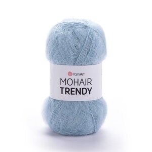 May include: A ball of pale blue mohair yarn with a white label displaying "YarnArt MOHAIR TRENDY". The yarn appears soft and fluffy, suitable for knitting or crochet crafts.