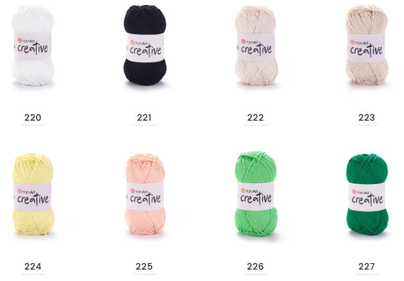May include: A selection of YarnArt Creative yarn balls in various colours, including white, black, cream, tan, yellow, light pink, green, and dark green. Each ball has a label with "creative" printed on it and a number from 220 to 227 below.