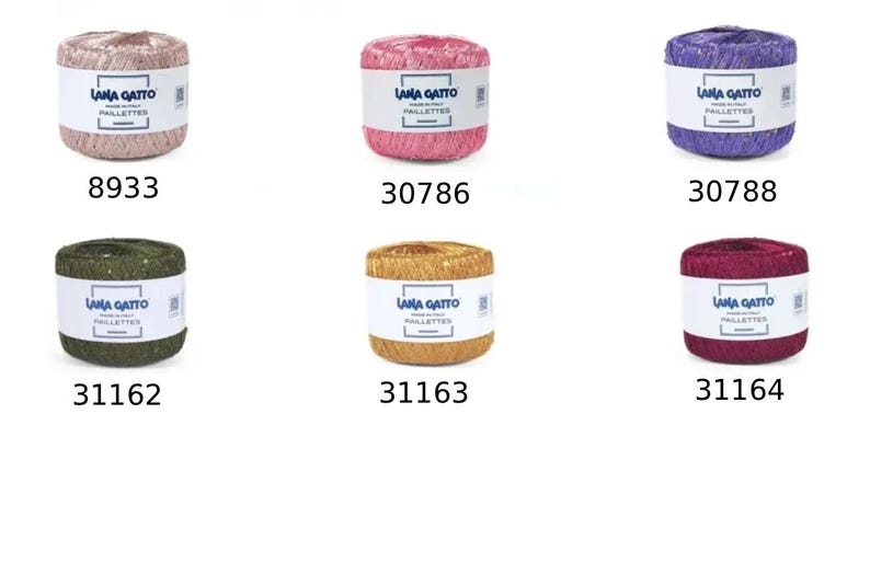 K&ouml;nnte beinhalten: Sechs zylindrische Garnkn&auml;uel von Lana Gatto Paillettes in verschiedenen Farben, darunter Hellrosa, Pink, Lila, Dunkelgr&uuml;n, Gold und Magenta. Jedes Kn&auml;uel hat ein wei&szlig;es Papieretikett mit dem Markennamen und dem Farbcode: 8933, 30786, 30788, 31162, 31163 und 31164.