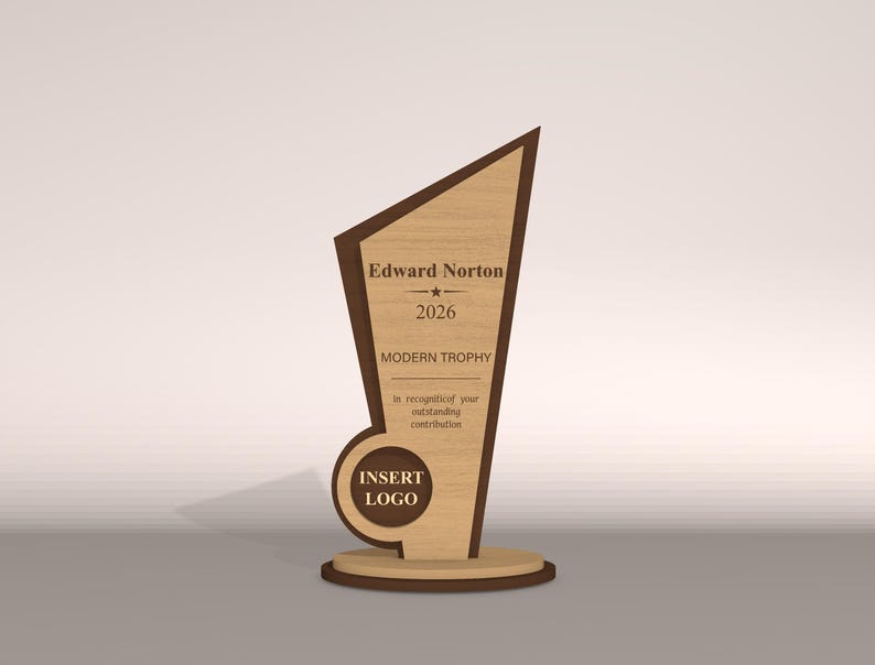May include: A wooden trophy with a light brown finish and dark brown accents. The trophy has a unique geometric shape with the text "Edward Norton", "2026", and "MODERN TROPHY". The base includes the text "INSERT LOGO".