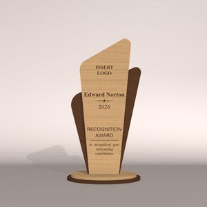 May include: A wooden recognition award with a light wood grain finish. The award features a unique shape with a dark brown accent and a circular base. Text on the award reads "INSERT LOGO", "Edward Norton", "2026", and "RECOGNITION AWARD".