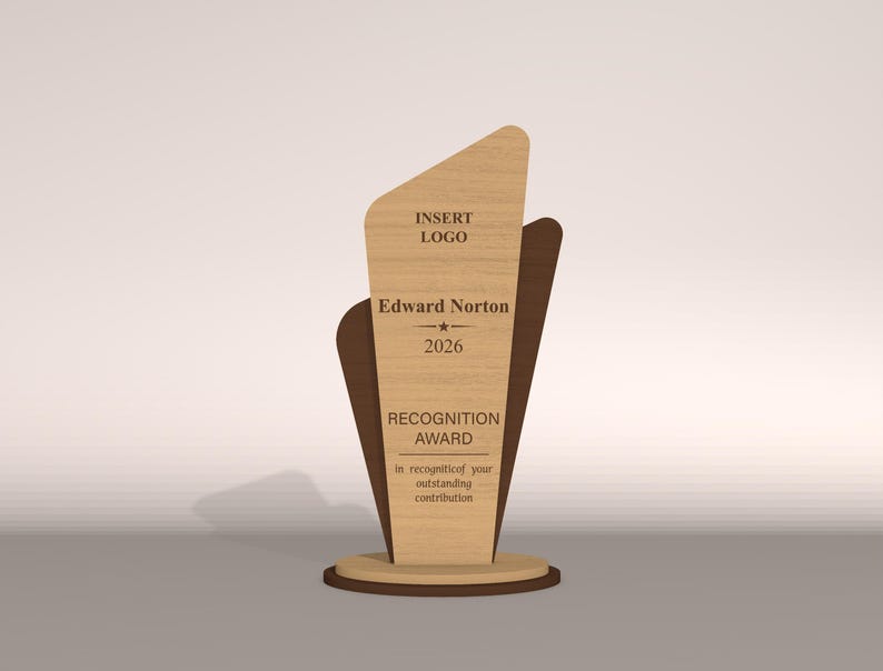 May include: A wooden recognition award with a light wood grain finish. The award features a unique shape with a dark brown accent and a circular base. Text on the award reads "INSERT LOGO", "Edward Norton", "2026", and "RECOGNITION AWARD".