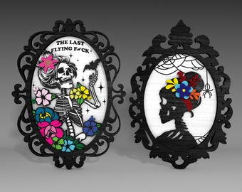 May include: Two black ornate frames with white backgrounds. The left frame features a skeleton with a floral crown and the text "The Last Flying F*ck". The right frame features a silhouette of a skull with a floral crown.