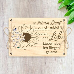 May include: Wooden sign with a sunflower and butterflies, with the text "In Deinem Licht bin ich erbl&uuml;ht durch deine Liebe Liebe habe ich fliegen gelernt."