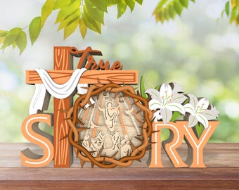 May include: A wooden sign with the words "True Story" in orange letters. The sign features a cross with a white cloth draped over it, a crown of thorns, and a scene of Jesus Christ on the cross. The sign is surrounded by white lilies.