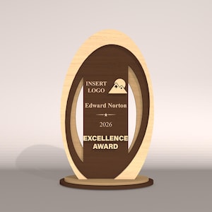 May include: A wooden Excellence Award with a light wood oval frame and a dark brown center. The center includes the text "INSERT LOGO", "Edward Norton", "2026", and "EXCELLENCE AWARD". A mountain and sun graphic is also present.