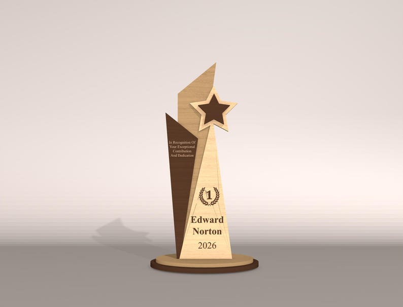 May include: A wooden trophy with a star and geometric design. The trophy has a brown star, a light brown and dark brown body, and a round base. Text on the trophy reads "Edward Norton 2026" and "In Recognition Of Your Exceptional Contribution And Dedication."