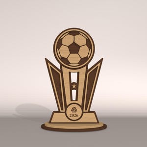 May include: Wooden soccer trophy with a soccer ball at the top. The trophy has a light brown base and a dark brown accent. The year 2026 is printed on the base. The trophy is designed with geometric shapes.