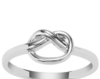 Op de afbeelding: Een zilverkleurige ring met een knoopontwerp. De ring heeft een gepolijste afwerking en een eenvoudige band. De knoop is het centrale punt, met zijn verweven lussen die een visueel aantrekkelijk en symbolisch sieraad creëren.