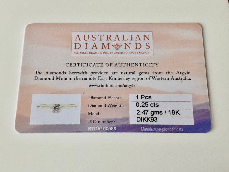 Puede incluir: Certificado de autenticidad para un anillo de diamantes. El certificado indica que el diamante es de 0,25 quilates y est&aacute; engastado en oro de 18 quilates. El anillo pesa 2,47 gramos y tiene un n&uacute;mero de identificaci&oacute;n &uacute;nico: RTDA100586. El certificado tambi&eacute;n indica que el diamante proviene de la mina de diamantes de Argyle en Australia Occidental.