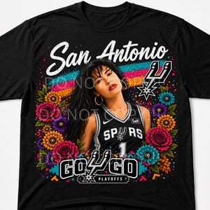 Puede incluir: Camiseta negra con un dise&ntilde;o floral colorido y el texto "San Antonio". La camiseta incluye una imagen de una mujer con una camiseta de los Spurs. Tambi&eacute;n se ve el texto "Go Go Playoffs".