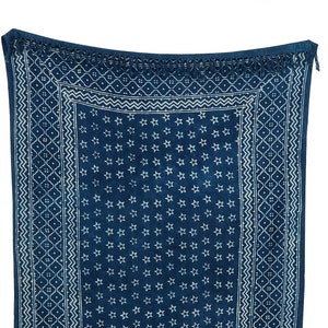 Op de afbeelding: Een blauwe en witte gestreepte deken met een franje rand. De deken heeft een herhalend stervormig patroon.