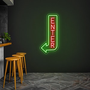 May include: Green neon sign with a red "ENTER" sign and a left-facing arrow. The sign is mounted on a black wall.