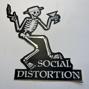 May include: Black and white sticker featuring a skeleton wearing a hat, holding a cigarette and a martini. The skeleton is seated with the text "SOCIAL DISTORTION" below it.