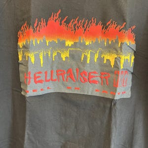 May include: Black t-shirt with a red and yellow graphic of a city skyline engulfed in flames. The text "HELLRAISER III" is printed below the graphic.