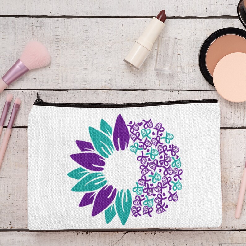 May include: White zippered makeup bag with a purple and teal sunflower design. The sunflower is made up of multiple purple and teal ribbon shapes.