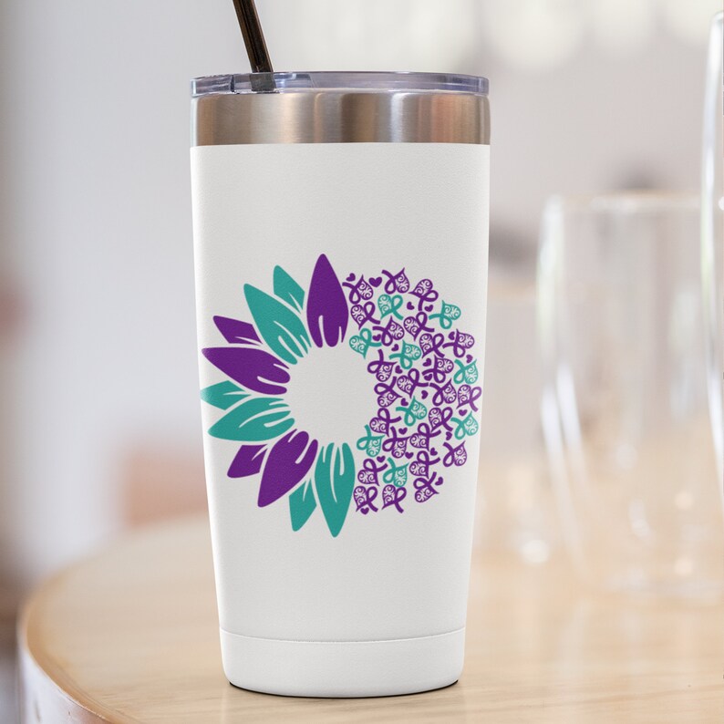 May include: White stainless steel tumbler with a teal and purple sunflower design. The sunflower is made up of multiple teal and purple ribbon shapes.