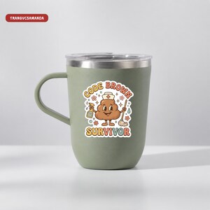 May include: A sage green stainless steel mug with a handle and a clear lid. The front features a cartoon graphic of a brown character wearing a nurse cap, holding a spray bottle and a mop, with the text "CODE BROWN SURVIVOR" in colorful letters.