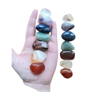 Op de afbeelding: Set van zeven chakra stenen, elk representatief voor een andere chakra kleur: helder, paars, blauw, groen, bruin, oranje en rood.