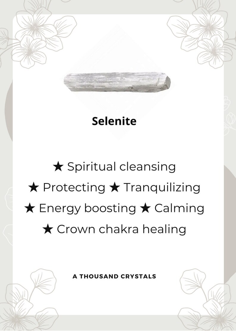 May include: A white selenite crystal, a type of mineral known for its calming and cleansing properties. The text on the card reads "Selenite", "Spiritual cleansing", "Protecting", "Tranquilizing", "Energy boosting", "Calming", "Crown chakra healing", and "A Thousand Crystals".