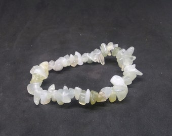 May include: A white and green gemstone chip bracelet. The bracelet is made of small, irregular shaped chips of white and green gemstone.