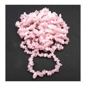 May include: A strand of pink rose quartz chip beads, with a smaller strand of the same beads forming a bracelet.