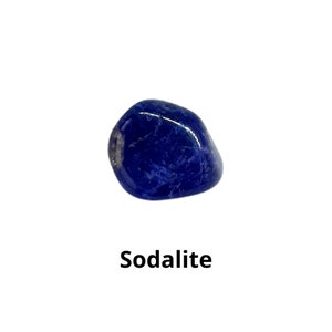 K&ouml;nnte beinhalten: Ein glatter, dunkelblauer Sodalith-Edelstein mit wei&szlig;en Adern. Der Stein ist getrommelt und hat eine abgerundete Form.
