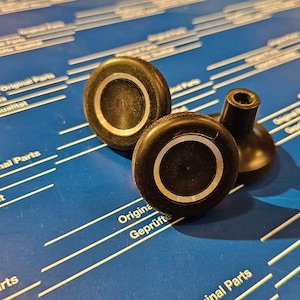 Op de afbeelding: Drie zwarte rubberen meubelpoten met een witte ring aan de bovenkant. De poten zijn ontworpen om vloeren te beschermen tegen krassen.