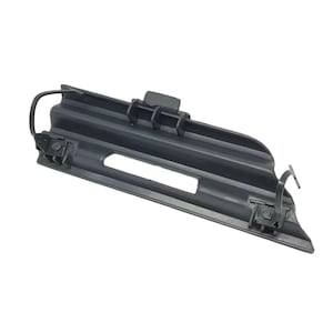 以下が含まれることがあります： テクスチャ加工された表面と2つのクリップが付いた黒いプラスチック製の自動車部品。部品は長方形で、中央にスロットがあります。