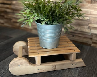 Sustainable decoration idea: upcycled sleigh flower stand or candle holder made from old wood