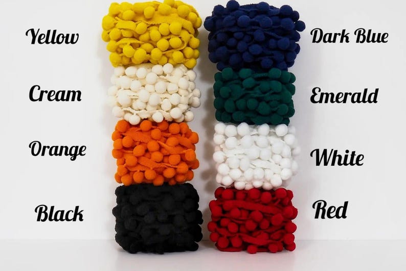 May include: A collection of colorful pom-pom trim in various shades, including yellow, cream, orange, black, dark blue, emerald, white, and red. The image displays the colors with corresponding text labels.
