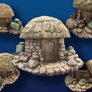 May include: Five miniature stone houses with thatched roofs. Each house has a small door and windows. The houses are surrounded by small stones and rocks.