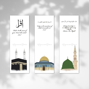 Puede incluir: Juego de tres marcadores blancos con caligrafía islámica e ilustraciones de lugares religiosos. Cada marcador presenta un diseño diferente, incluyendo la Kaaba, la Cúpula de la Roca y la Mezquita del Profeta.