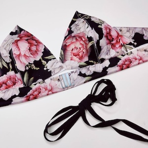 Peut inclure: Un soutien-gorge triangle à imprimé floral noir avec des bretelles réglables et un ruban noir à nouer.