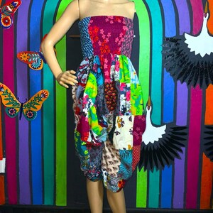 May include: A colorful patchwork strapless jumpsuit with a variety of floral and geometric patterns. The jumpsuit is made of a soft, flowing fabric and has a relaxed fit.