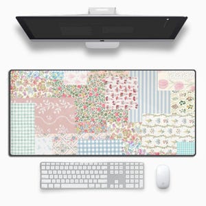 May include: A large, rectangular desk mat with a patchwork design featuring various floral patterns in shades of pink, blue, and green. The mat is made of a durable material and is perfect for protecting your desk from scratches and spills.