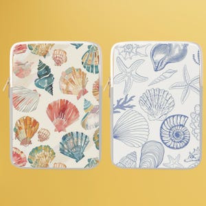 Op de afbeelding: Twee laptophulzen met verschillende ontwerpen. Een hoes heeft een aquarel schelpmotief in tinten roze, blauw en geel. De andere hoes heeft een lijntekening van schelpen en zeesterren in blauw op een witte achtergrond.