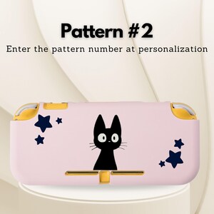 May include: A pink handheld gaming console case featuring a black cat illustration and navy blue star accents. The case has gold-colored accents and the text "Pattern #2" and "Enter the pattern number at personalization".