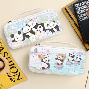 May include: Two white carrying cases with panda designs. One case features a panda family among flowers, the other shows pandas near water. Both cases have a white handle and zipper.