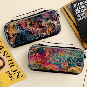 May include: Two rectangular cases with floral designs. The cases have a black border, a white handle, and a zip closure. The floral patterns feature a mix of colours, including pink, orange, blue, and gold. The cases appear to be for electronic devices.