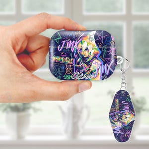 May include: AirPods case and keychain featuring a colorful illustration of a character with the name "Jinx" and the name "Oliver". The design includes graffiti-style elements and a vibrant color palette, with a dark blue background.
