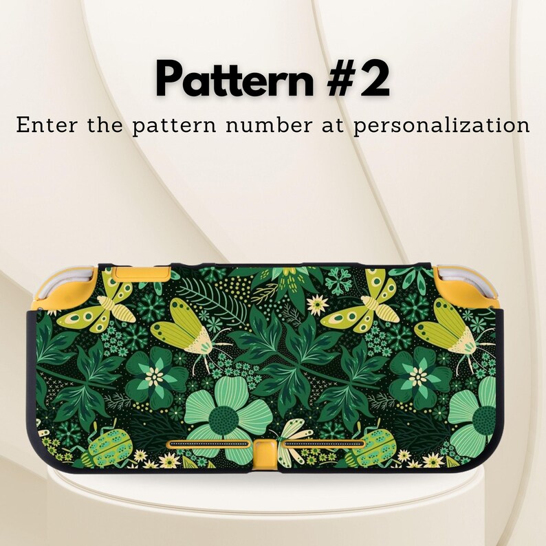 May include: A black and green patterned Nintendo Switch Lite case. The case features a floral and insect design with butterflies, flowers, and leaves. The text "Pattern #2" and "Enter the pattern number at personalization" are displayed on the image.