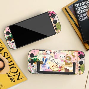 May include: Two Nintendo Switch consoles with colorful, patterned skins. One console is fully assembled, while the other has the screen detached. The skins feature a mix of cartoon characters, flowers, and pastel colors.