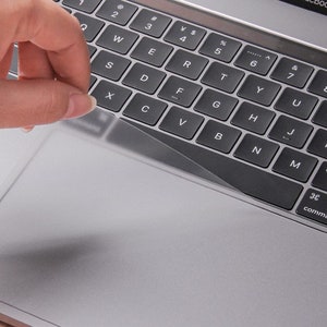 Pu&ograve; includere: Una copertura trasparente in plastica per tastiera e trackpad per un laptop. La copertura viene applicata alla tastiera e al trackpad del laptop.