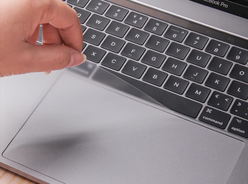 Pu&ograve; includere: Una copertura trasparente in plastica per tastiera e trackpad per un laptop. La copertura viene applicata alla tastiera e al trackpad del laptop.