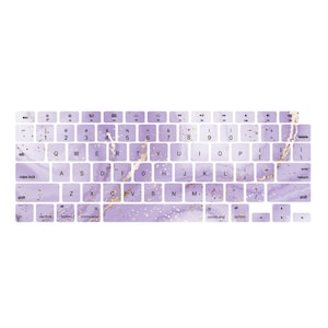 May include: A keyboard cover with a purple and gold marble design. The cover features all the standard keys for a laptop keyboard, including function keys, arrow keys, and number keys.