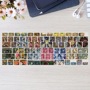 Puede incluir: Una funda de teclado con un diseño colorido y estampado. Las teclas están decoradas con varios patrones florales y geométricos en tonos rojos, azules, verdes y amarillos. La funda está colocada sobre una superficie de madera clara.