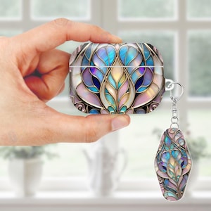 May include: A decorative AirPod case and matching keychain with a stained-glass design. The case and keychain feature a floral pattern in shades of blue, purple, pink, and gold, with a silver-colored metal trim and keychain ring.
