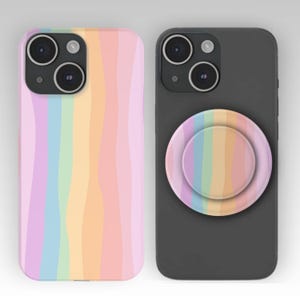 May include: Two phone cases with a pastel rainbow design. One case is a solid pastel rainbow pattern, and the other is a dark gray case with a matching rainbow pop-socket. The cases have a glossy finish.